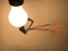 incandescent bulb on the solar panel brightly lights a super red LED bulb